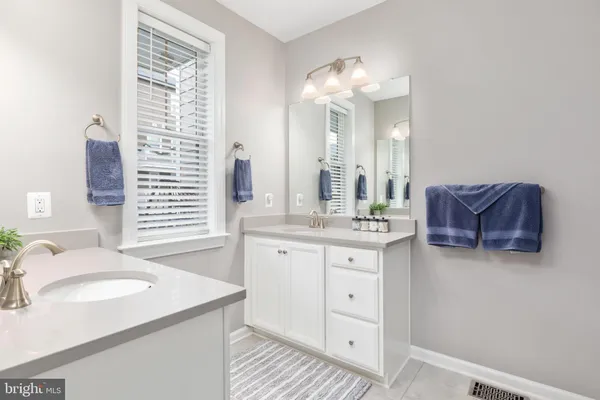 a spacious bathroom with double vanity and a mirror