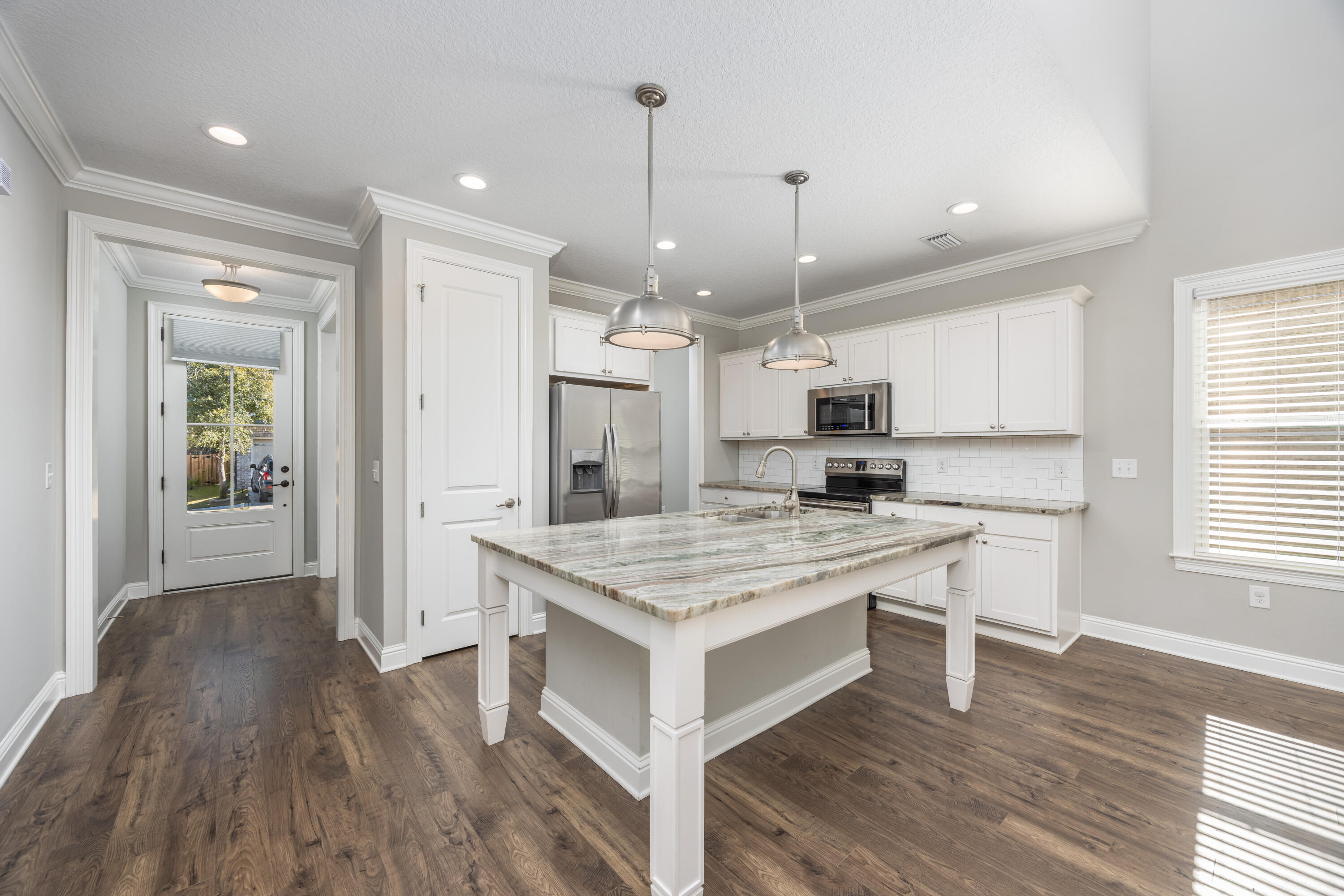 134 Laurel Oaks Drive Freeport, FL 32439 - Photo 9 of 30 a kitchen with stainless steel appliances kitchen island granite countertop a stove a refrigerator a sink and a oven with wooden floor