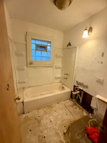 a bathroom with a tub sink and a shower