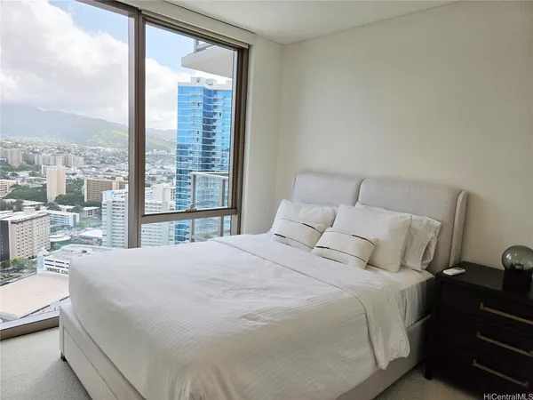 a large bed sitting in a bedroom next to a large window
