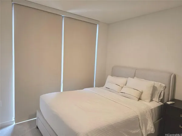 a large bed in a bedroom next to a window