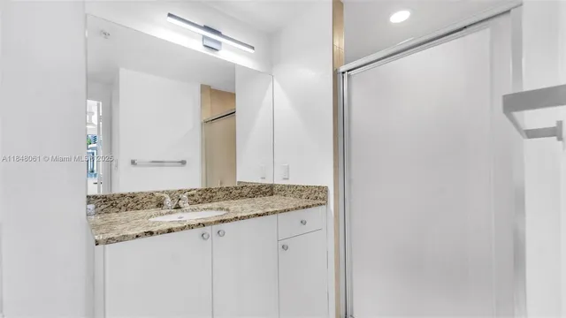 a bathroom with a granite countertop sink and a mirror