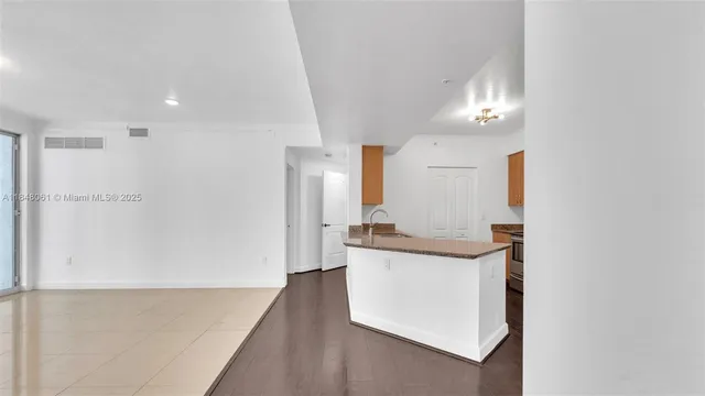 a kitchen with granite countertop a sink a stove and refrigerator