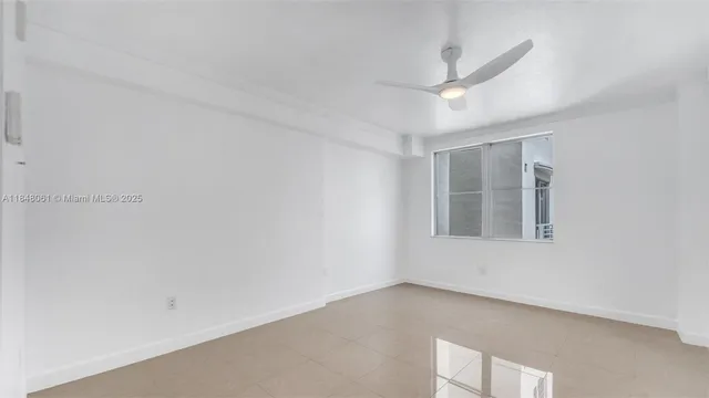 an empty room with a ceiling fan and window