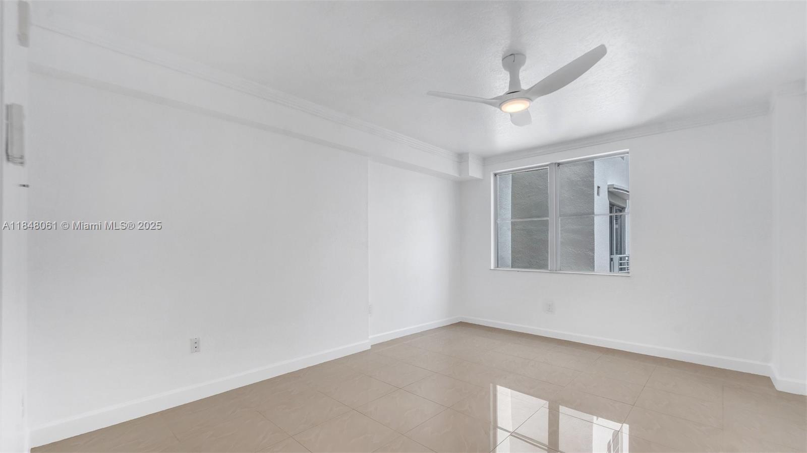1830 Radius Drive, Unit 405 Hollywood, FL 33020 - Photo 8 of 19 an empty room with a ceiling fan and window