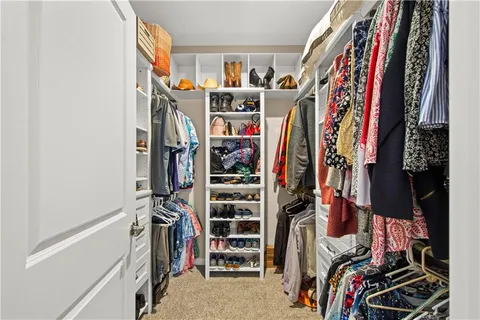 a view of walk in closet with clothes and shoes