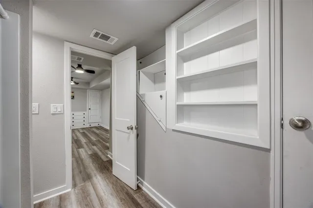 a view of a hallway with wooden floor and staircase