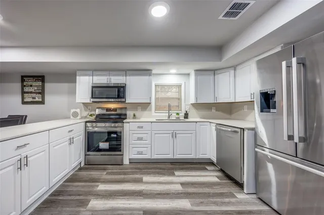 a kitchen with granite countertop a refrigerator stove and sink