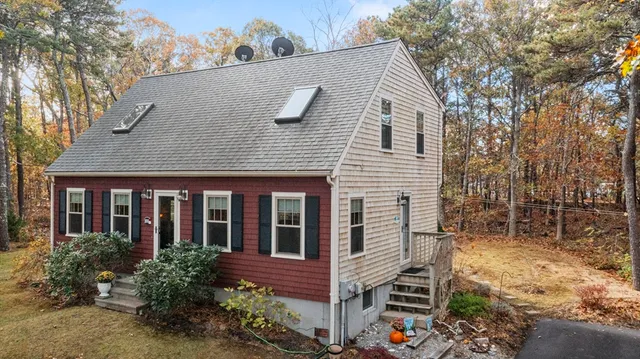 a view of house with a yard and a large tree