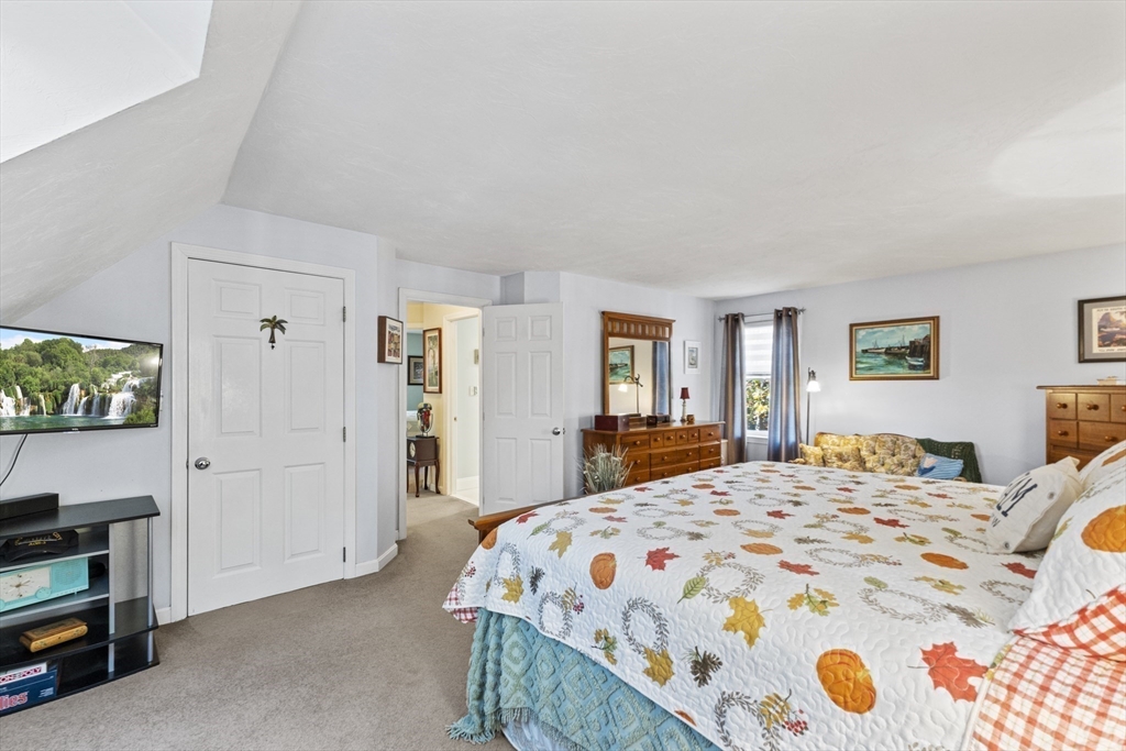 100 Orchard Drive Eastham, MA 02642 - Photo 17 of 31 a bedroom with a bed and a flat screen tv