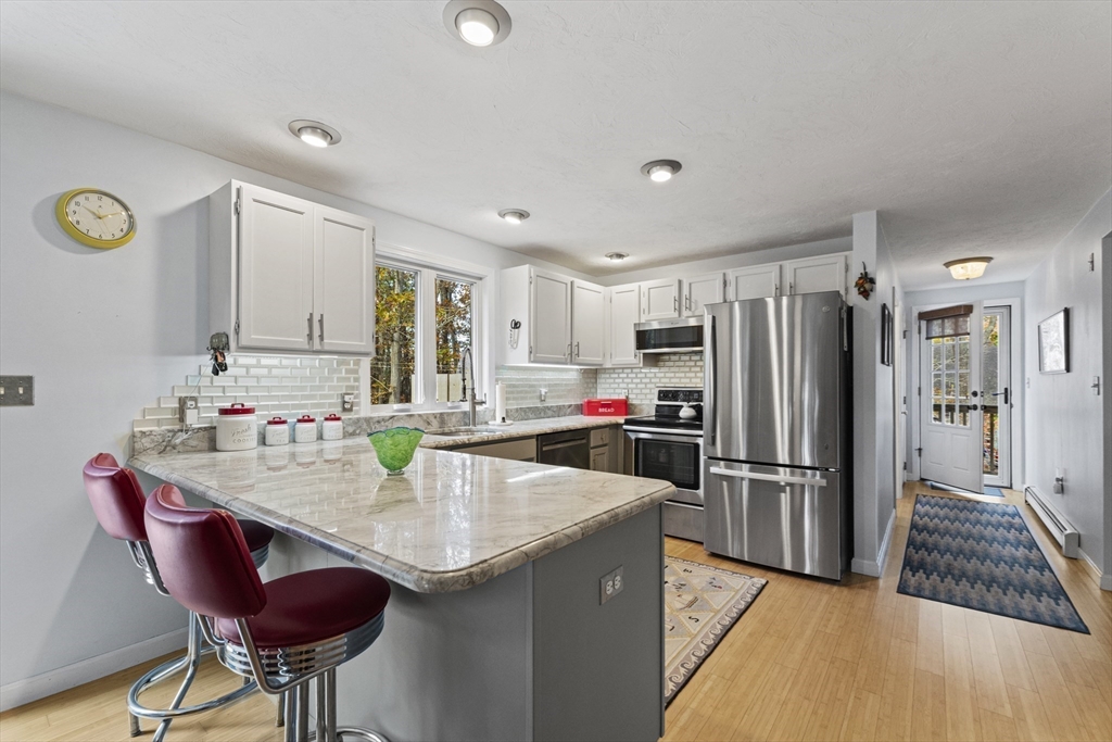 100 Orchard Drive Eastham, MA 02642 - Photo 2 of 31 a kitchen with refrigerator and chairs