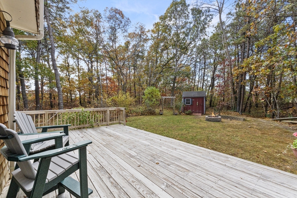 100 Orchard Drive Eastham, MA 02642 - Photo 28 of 31 a view of a patio with table and chairs and wooden fence