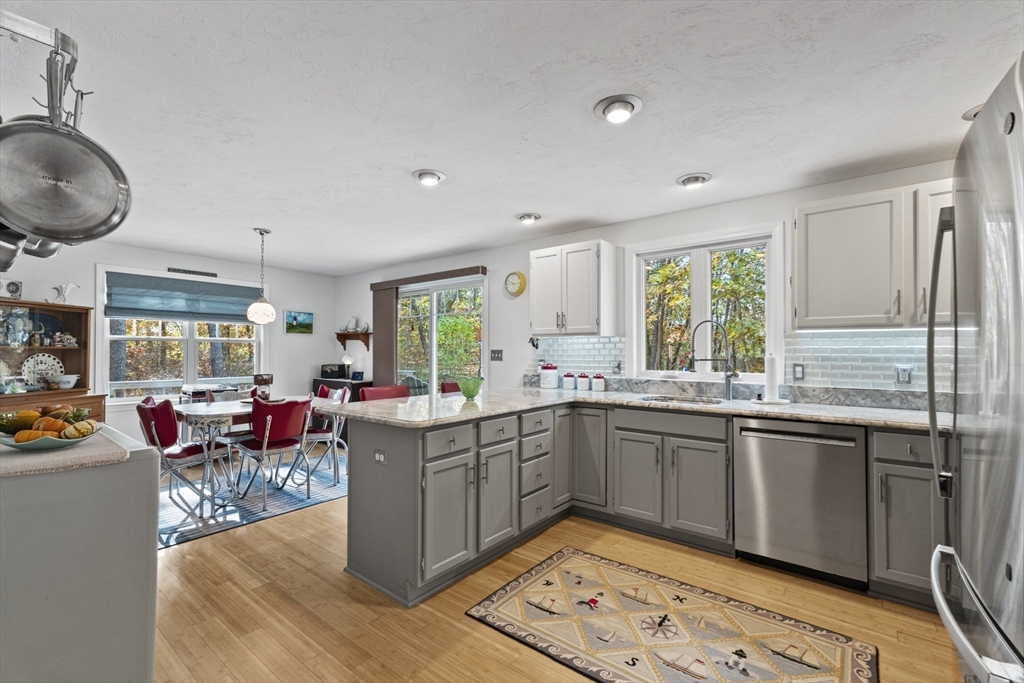 100 Orchard Drive Eastham, MA 02642 - Photo 3 of 31 a kitchen with stainless steel appliances granite countertop a sink dishwasher stove and wooden cabinets