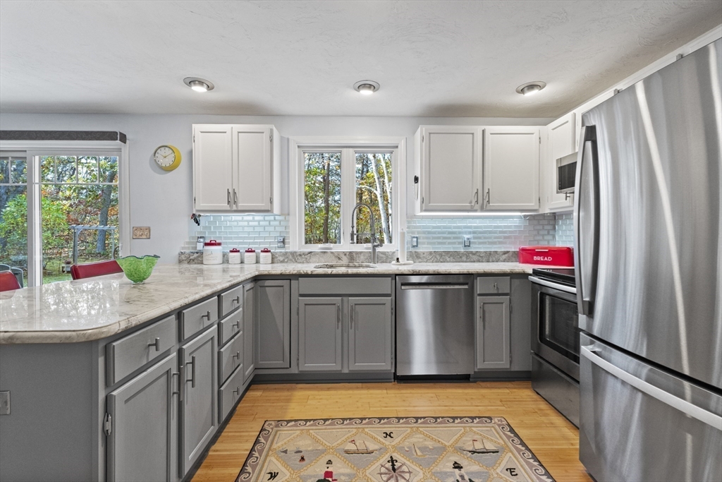 100 Orchard Drive Eastham, MA 02642 - Photo 4 of 31 a kitchen with granite countertop stainless steel appliances a sink stove refrigerator and window