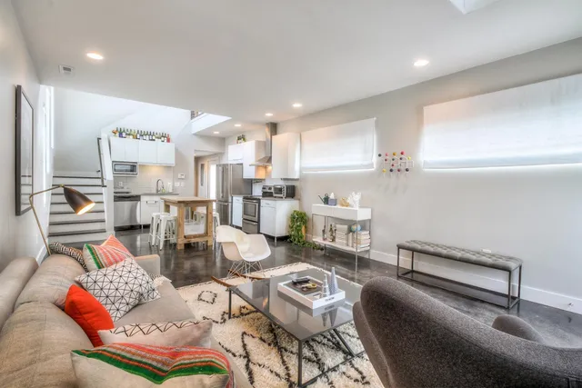 a living room with lots of furniture and kitchen view