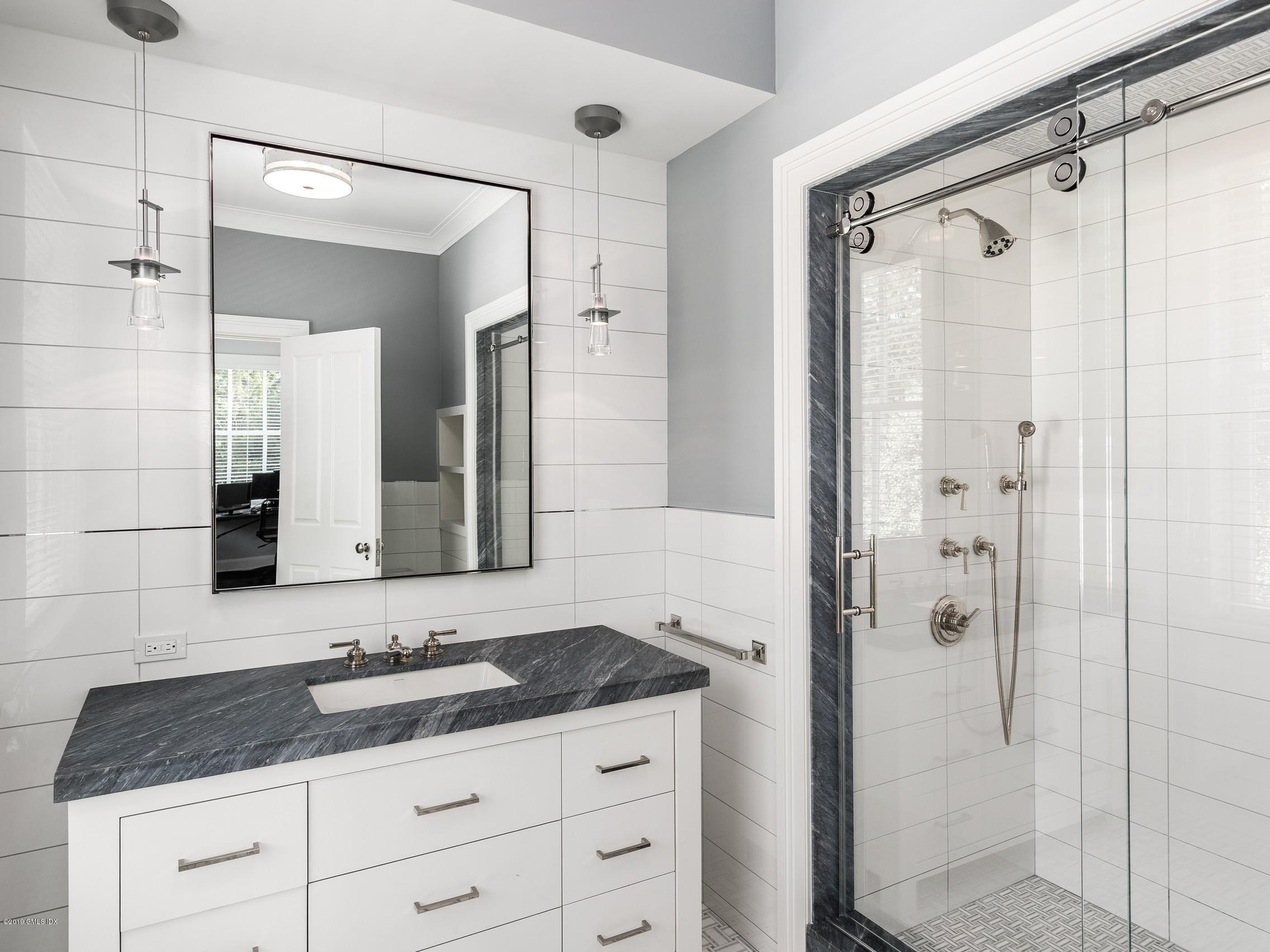 16 Andrews Farm Road Greenwich, CT 06831 - Photo 23 of 44 a bathroom with a granite countertop sink a mirror a glass door a shower and vanity