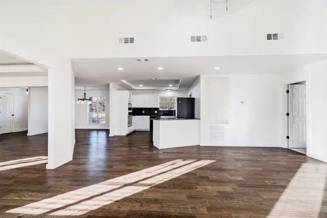 a view of a livingroom with wooden floor and a ceiling fan
