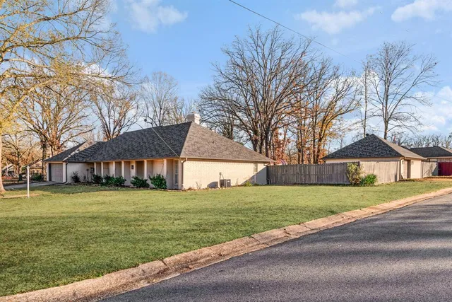 a view of a big house with a big yard and large trees