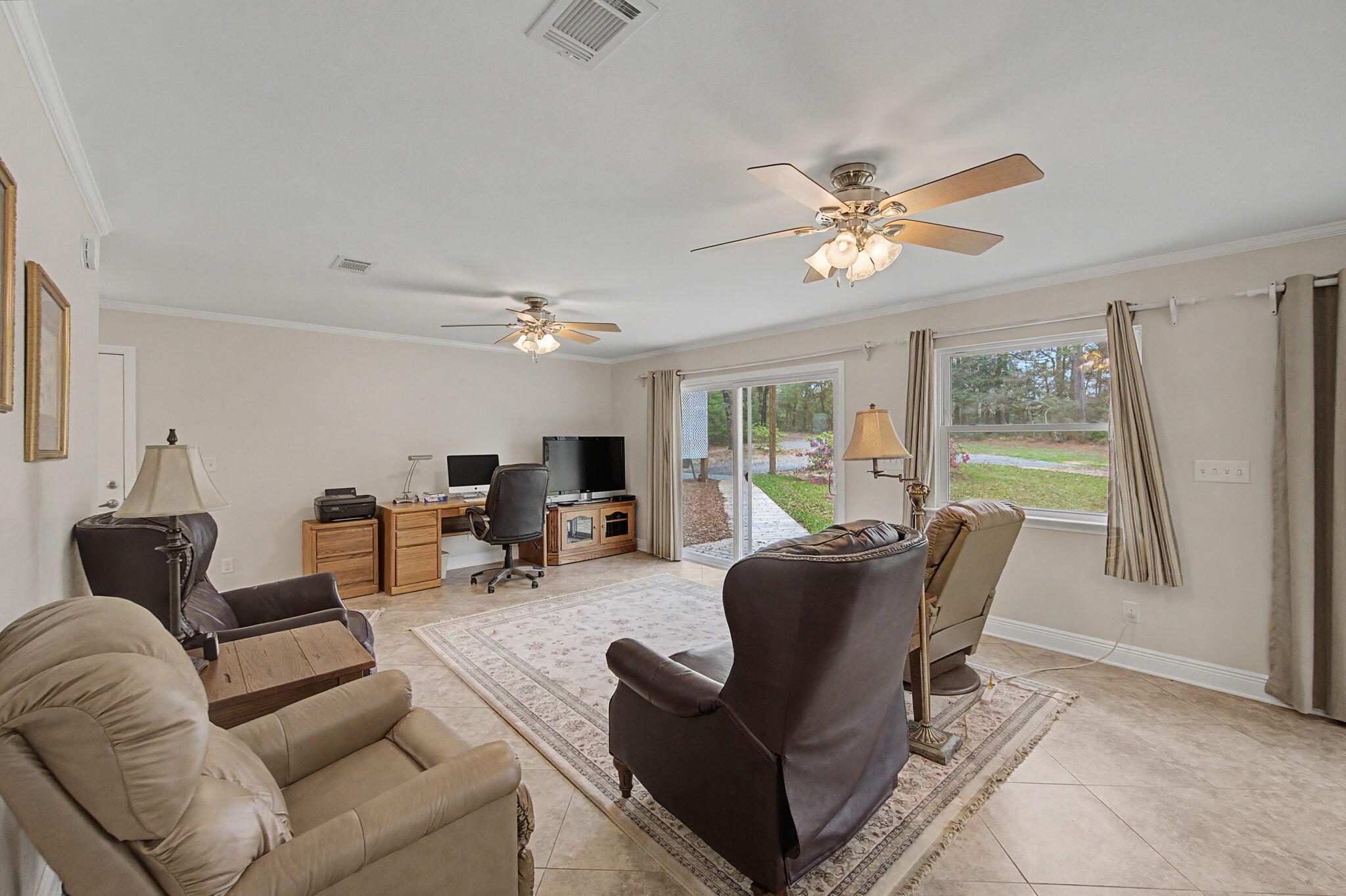 6730 Owens Road Laurel Hill, FL 32567 - Photo 17 of 36 a living room with furniture a ceiling fan a fireplace and a window