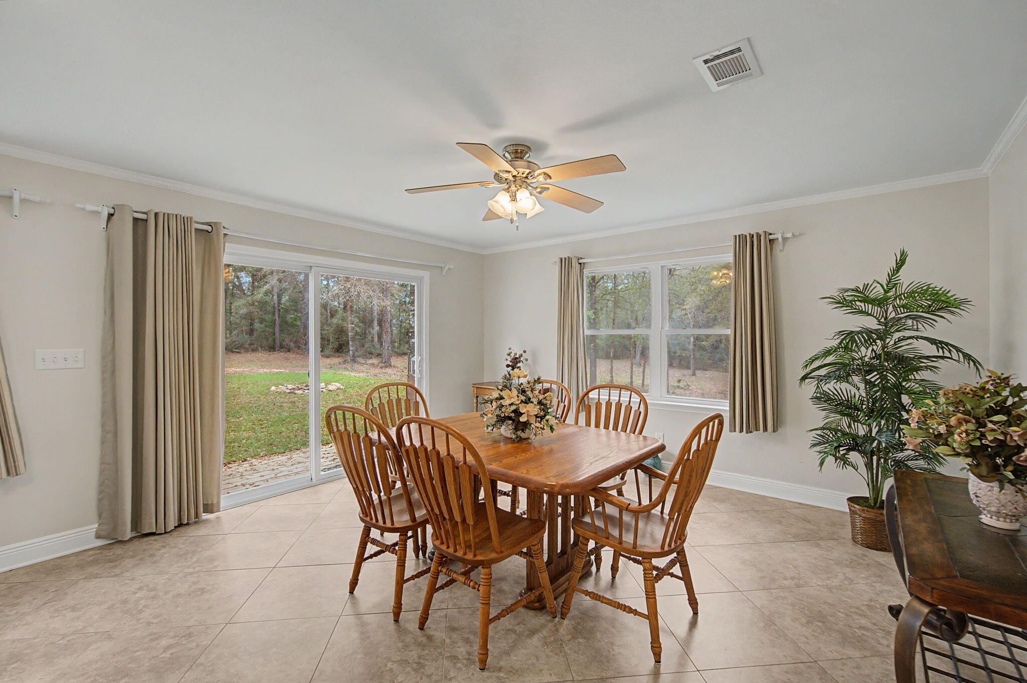 6730 Owens Road Laurel Hill, FL 32567 - Photo 18 of 36 a dining room with furniture potted plants and a large window