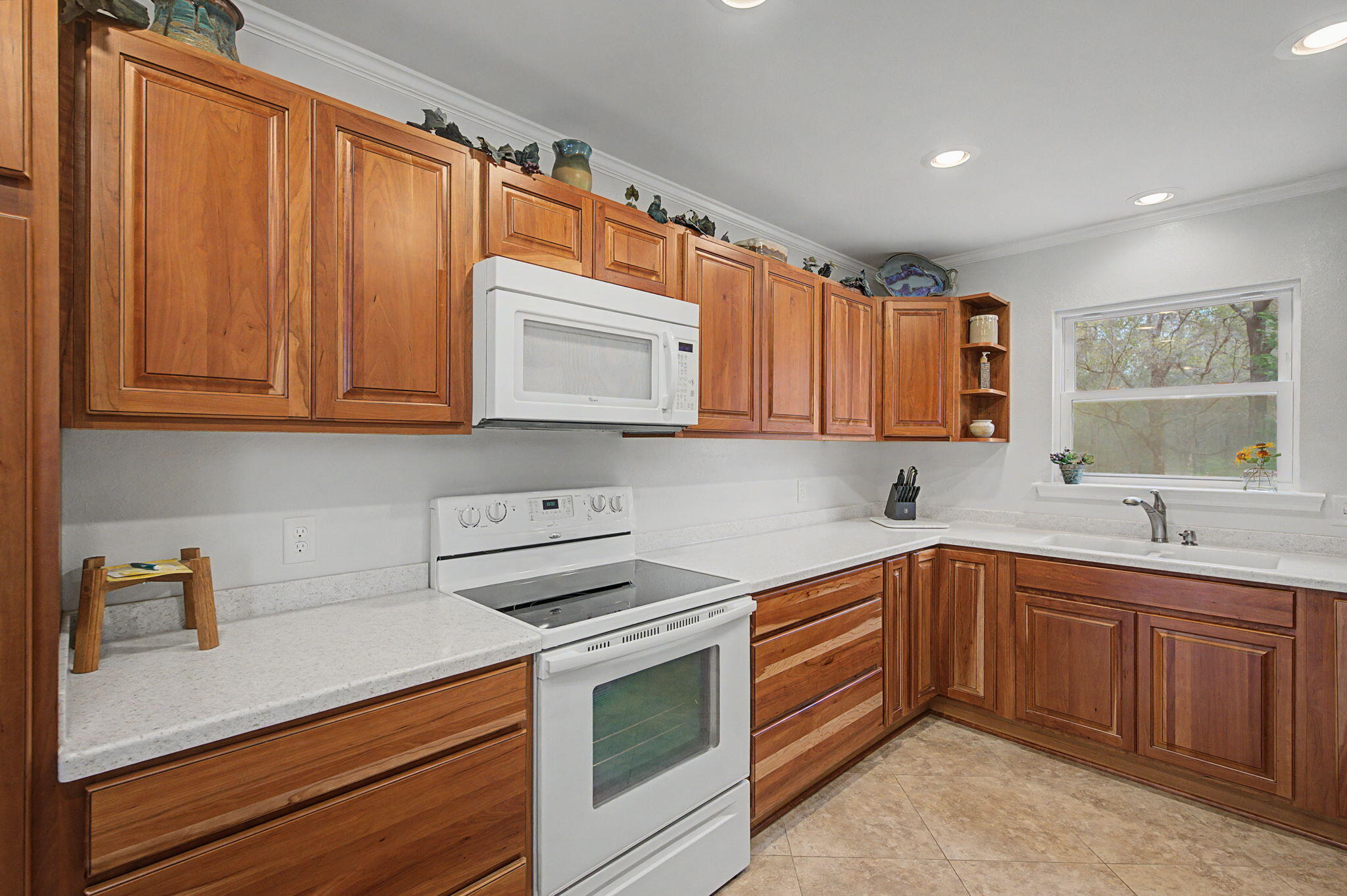 6730 Owens Road Laurel Hill, FL 32567 - Photo 27 of 36 a kitchen with stainless steel appliances granite countertop a sink dishwasher stove and microwave with wooden cabinets
