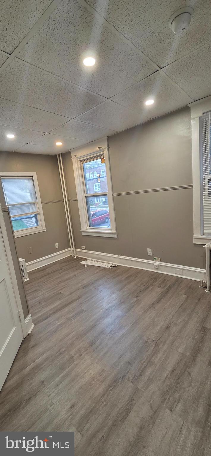 131 MacDade Boulevard, Unit 2F Collingdale, PA 19023 - Photo 7 of 14 an empty room with wooden floor and windows