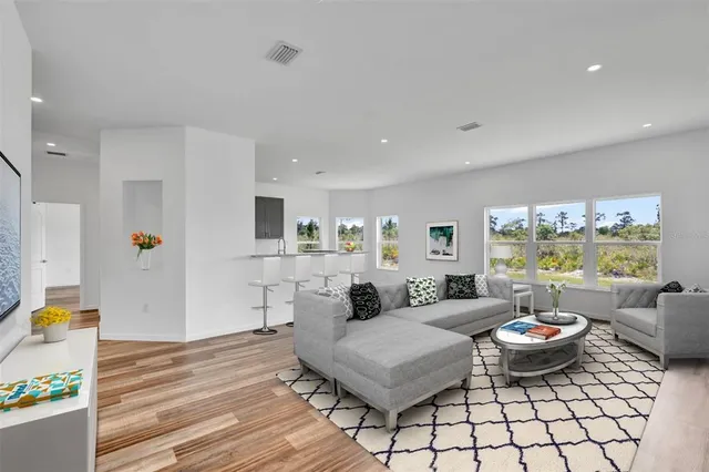 a living room with furniture a flat screen tv and a table