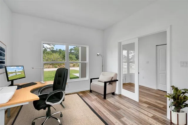 a view of a workspace with furniture and a window
