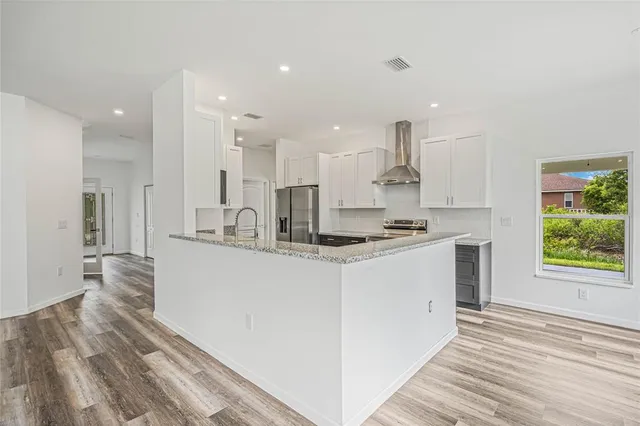 a kitchen with kitchen island sink stove and refrigerator