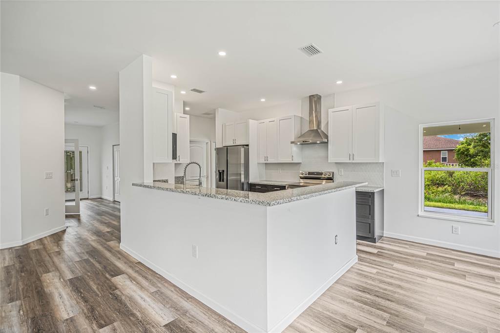 8001 Leonardo Street Sebring, FL 33872 - Photo 10 of 32 a kitchen with kitchen island sink stove and refrigerator