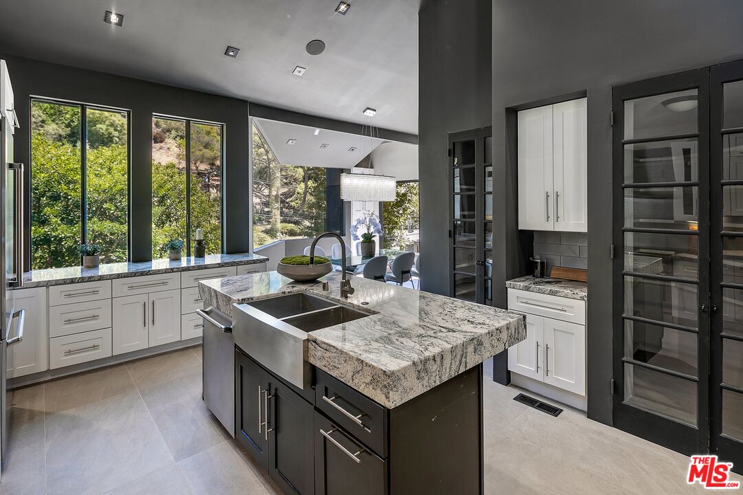 2001 Roscomare Road Los Angeles, CA 90077 - Photo 19 of 62 a kitchen that has a lot of white cabinets and stainless steel appliances