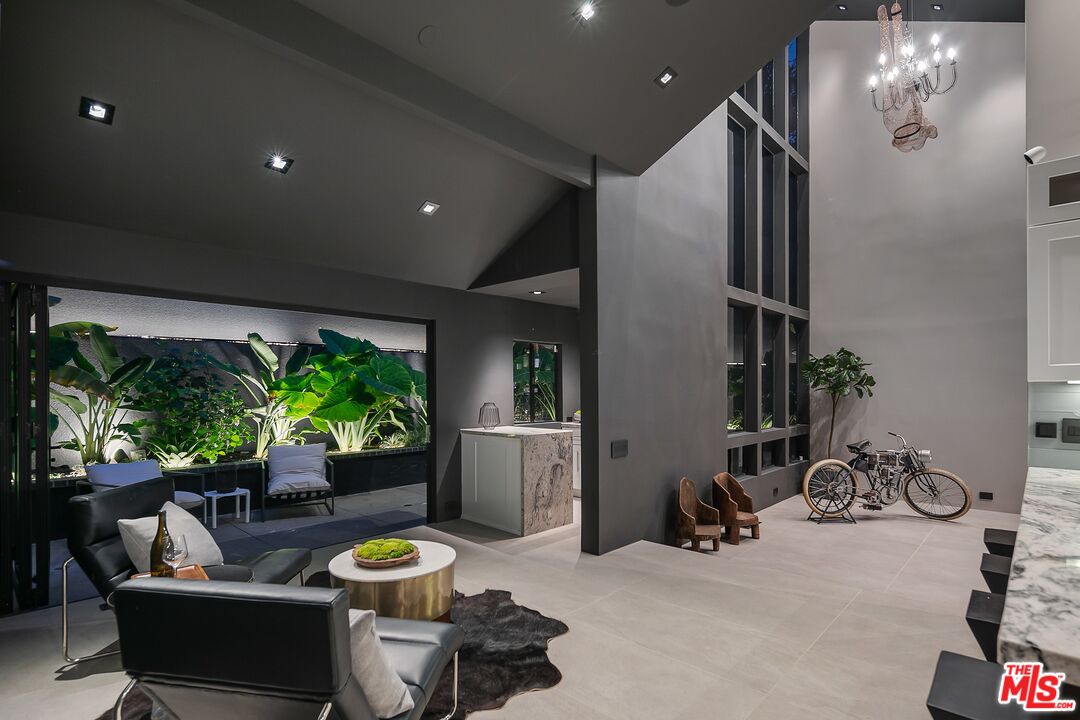 2001 Roscomare Road Los Angeles, CA 90077 - Photo 47 of 62 a living room with furniture potted plant and a large window