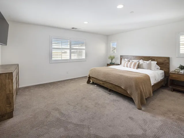 a bed sitting in a bedroom next to a bathroom