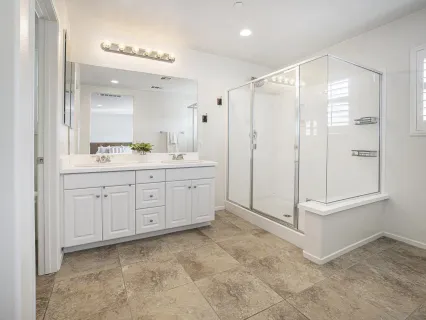 a spacious bathroom with a double vanity sink a mirror and a toilet