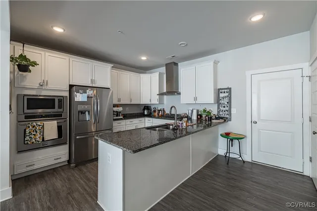 a kitchen with stainless steel appliances granite countertop a refrigerator and a stove top oven