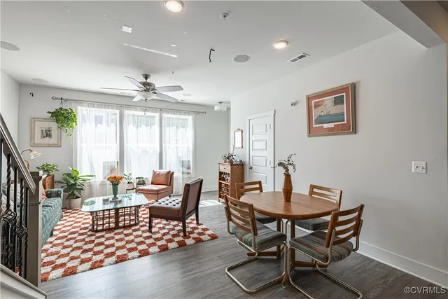 a kitchen with a dining table chairs and wooden floor