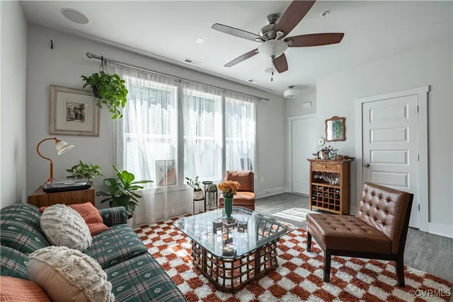 a living room with furniture and a ceiling fan