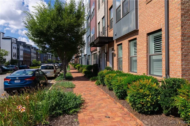 a city street lined with buildings and cars parked on the roadside