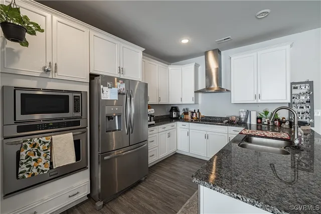 a kitchen with granite countertop a refrigerator stove and sink