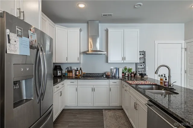 a kitchen with stainless steel appliances granite countertop a sink a stove and cabinets