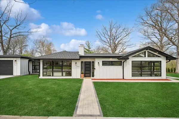 a front view of a house with a yard and trees