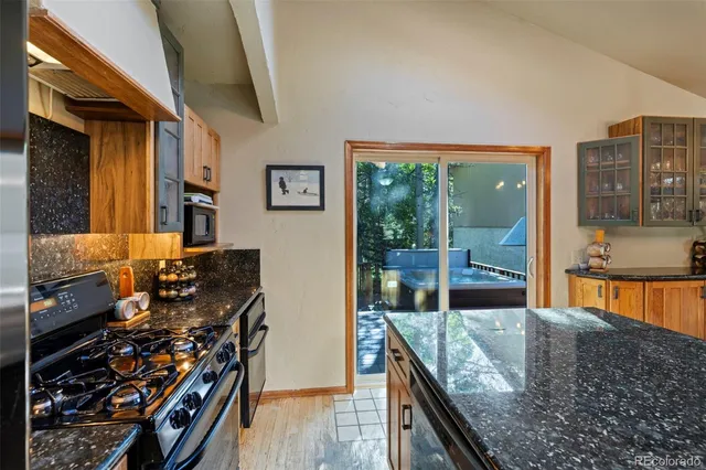 a kitchen with stainless steel appliances granite countertop a stove and a large window