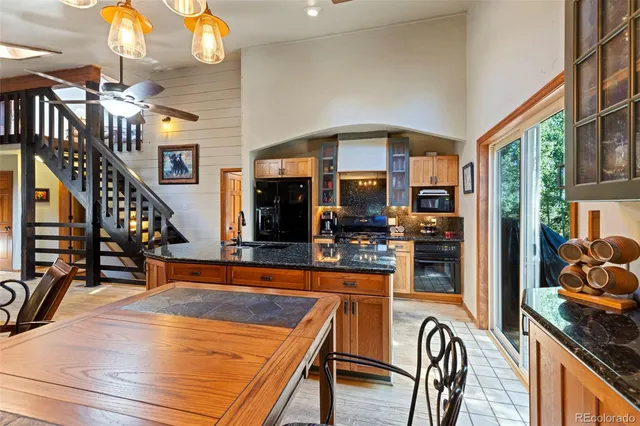 a view of a kitchen with stainless steel appliances granite countertop a table chairs in it