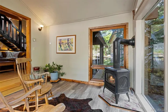 a dining room with furniture a floor to ceiling window and wooden floor