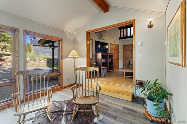 a dining room with furniture potted plants and wooden floor