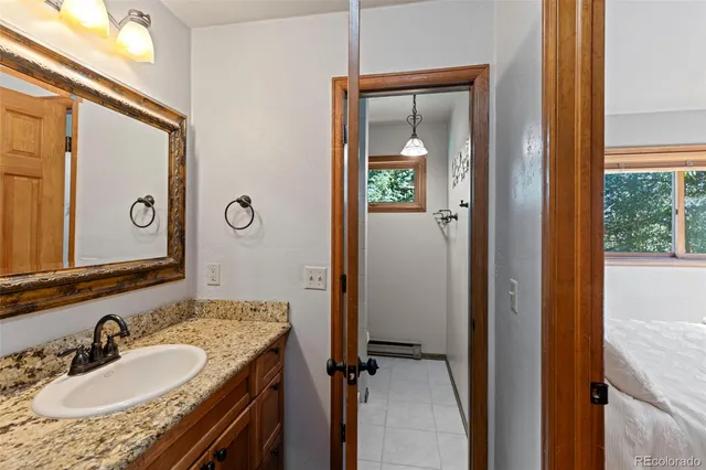 a bathroom with a granite countertop sink and a mirror
