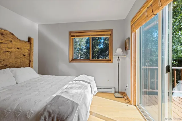 a bedroom with a bed and a large window with outer view