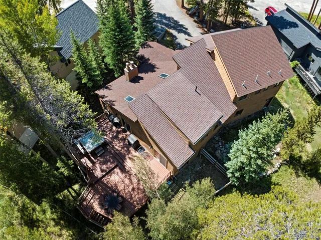 an aerial view of a house with a yard and a large tree