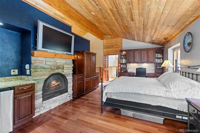 a bed room with a fireplace chair and a television