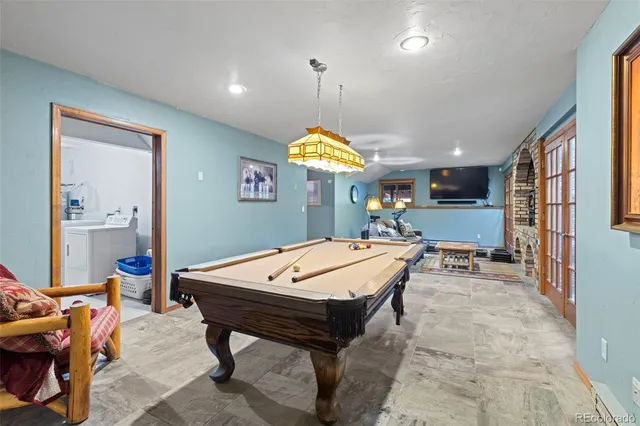 a room with furniture pool table and window